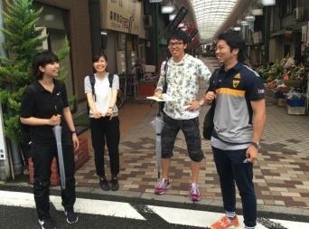 参加者4人が商店街の入り口付近で笑顔で写っている写真