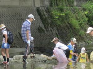 男性が段差のある場所を登ろうとしている子供を見守っている写真